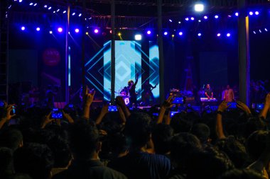 Grubun çaldığı her şarkının tadını çıkarıyorum. Bir müzik konserinde büyük bir kalabalığın fotoğrafını çektim. Gitaristler ve Davulcu 'nun konserde çaldığı rock grubu. Bangladeşli grup Shironamhin konseri.