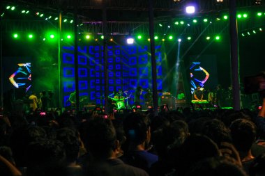 Grubun çaldığı her şarkının tadını çıkarıyorum. Bir müzik konserinde büyük bir kalabalığın fotoğrafını çektim. Gitaristler ve Davulcu 'nun konserde çaldığı rock grubu. Bangladeşli grup Shironamhin konseri.