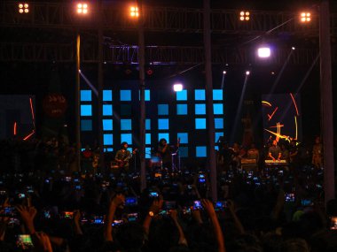 Grubun çaldığı her şarkının tadını çıkarıyorum. Bir müzik konserinde büyük bir kalabalığın fotoğrafını çektim. Gitaristler ve Davulcu 'nun konserde çaldığı rock grubu. Bangladeşli grup Shironamhin konseri.