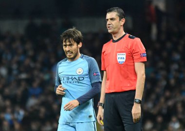 MANCHESTER, ENGLAND - NOVEMBER 1, 2016: Manchester City ve FC Barcelona arasında oynanan UEFA Şampiyonlar Ligi C Grubu maçında şehir ve Macar hakem Viktor Kassai 'den David Silva (L). Telif Hakkı: Cosmin 