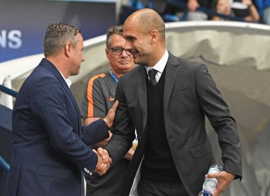 MANCHESTER, ENGLAND - 24 AUGSTOS 2016: Etihad St City (Engaland) ile FCSB (Romanya) arasındaki 2016 / 17 UEFA Şampiyonlar Ligi ikinci ayağı öncesinde FCSB teknik direktörü Laurentiu Reghecampf 'i (L) karşıladı.