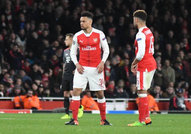 LONDON, ENGLAND - 7 Mart 2017: Francis Coquelin (L) ve Arsenal takımlarından Alex Oxlade-Chamberlaine (R), Arsenal Stadyumu 'ndaki Arsenal FC ve Bayern Munchen arasında oynanan 16. Telif Hakkı: Cosmi