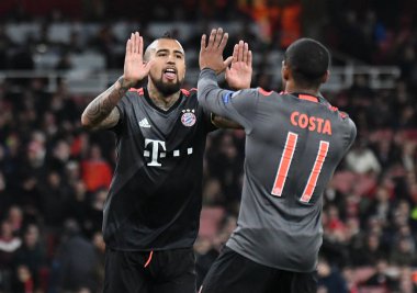 LONDON, ENGLAND - 7 Mart 2017: Bayern 'li Arturo Vidal, Emirates Stadyumu' ndaki Arsenal FC ve Bayern Munchen arasında oynanan 16 maçlık UEFA Şampiyonlar Ligi ikinci turunda attığı golün ardından Douglas Costa (R) tarafından kutlandı. Telif Hakkı