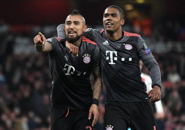 LONDON, ENGLAND - 7 Mart 2017: Bayern 'li Arturo Vidal, Emirates Stadyumu' ndaki Arsenal FC ve Bayern Munchen arasında oynanan 16 maçlık UEFA Şampiyonlar Ligi ikinci turunda attığı golün ardından Douglas Costa (R) tarafından kutlandı. Telif Hakkı