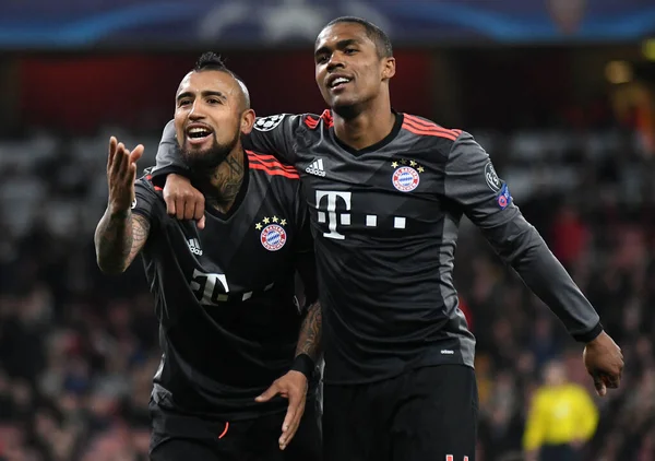 LONDON, ENGLAND - 7 Mart 2017: Bayern 'li Arturo Vidal, Emirates Stadyumu' ndaki Arsenal FC ve Bayern Munchen arasında oynanan 16 maçlık UEFA Şampiyonlar Ligi ikinci turunda attığı golün ardından Douglas Costa (R) tarafından kutlandı. Telif Hakkı