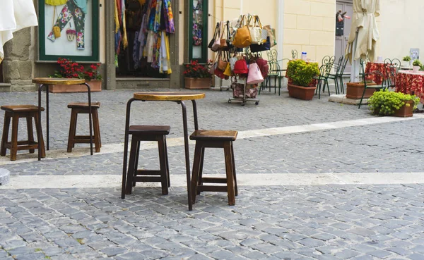 İtalya 'da eski bir caddedeki bir barda masa ve sandalye.