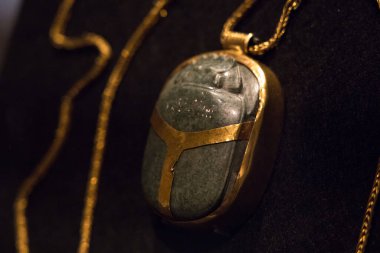 Leiden, The Netherlands - AUG 07, 2021: closeup of a golden scarab amulet from ancient egypt. Ancient jewellery.