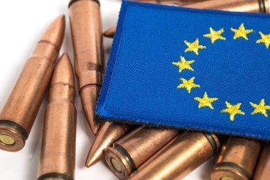 Silah mermileriyle AB bayrağına yaklaş. AB 'nin Ukrayna' ya silah ve mühimmat teslimatı. Avrupa 'ya askeri yardım. 7.62x39 tüfek mermisi. Ukrayna, Avrupa 'da Savaş.