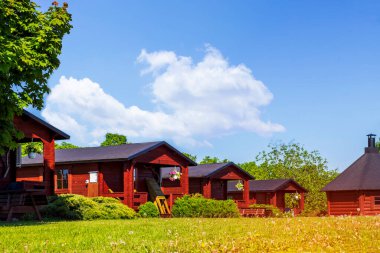 Ormandaki kamp parkında geleneksel ahşap bungalov sırası. Kamp parkındaki tatil evleri. Macera, seyahat, yaz tatili konsepti.