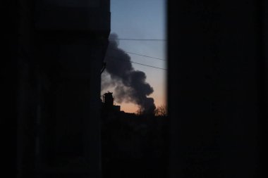 Chernihiv Ukrayna 03.24.2022 Rus saldırısından sonra şehirde yıkım gerçekleşti. Chernihiv yanıyor, uzaktan duman çıkıyor Chernihiv şehrinin bayrağının arka planında