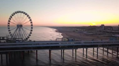 Hollanda 'nın Lahey kenti yakınlarındaki Kuzey Denizi Scheveningen Plajında Dönme Dönme Tekerlekli İskele - hava geri çekilmesi. Yüksek kalite 4k görüntü