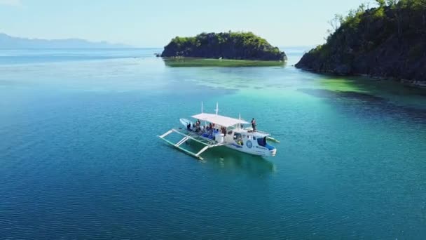在菲律宾巴拉望El Nido岛附近的深蓝色海面上乘船漂流的游客。-空中 — 图库视频影像