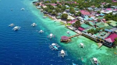 Filipinler 'in Moalboal şehrinde kristal berrak mavi suda yüzen turistler. - Hava.