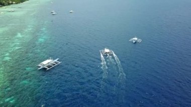 Moalboal, Cebu, Filipinler 'de Mavi Denizi aşan ahşap kayıklar. - Hava.