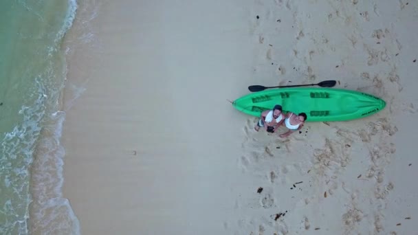 Пара поцілунків Біля зеленого каяка на узбережжі Ель-Нідо, Палаван. - повітряний підйом, вид зверху вниз. — стокове відео