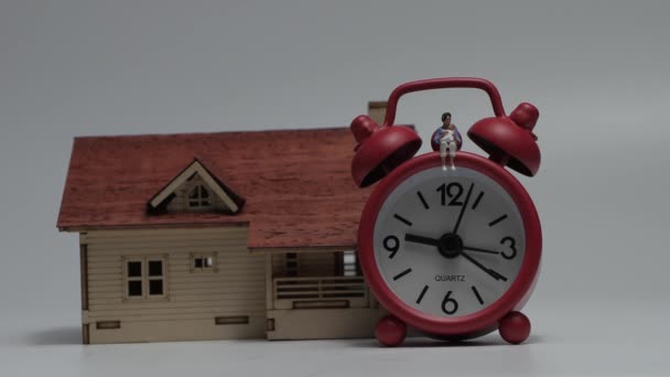 Miniature Woman Sitting Baby Red Alarm Clock Wooden Miniature House — Stockvideo