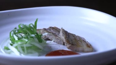 Beyaz tabakta ızgara domuz göbeği. Izgara domuz eti ve baharatlı soğan. Alkol için meze olarak çok popülerdir..