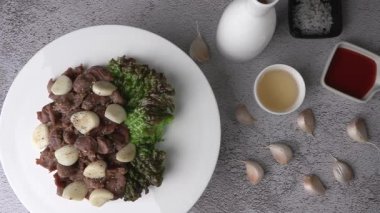 Kızarmış tavuk ve sarımsak. Kızarmış tavuk taşağı ve alkolle servis edilen sarımsak..