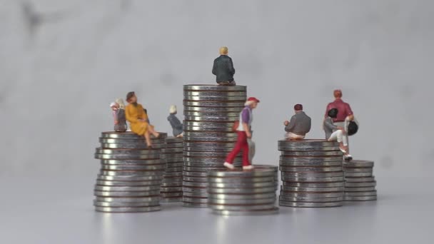 Miniatur Orang Berdiri Atas Tumpukan Ketinggian Yang Berbeda Dari Coins — Stok Video