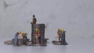 Modern toplumda ekonomik eşitsizlik kavramı. Minyatür insanlar ve bozuk para yığınları.