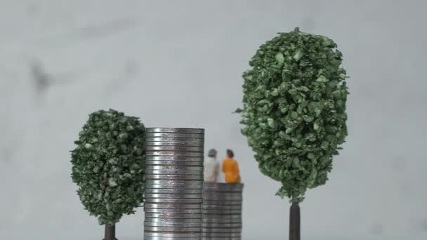 Ouderdom Miniatuur Mensen Een Stapel Munten Tussen Miniatuur Bomen Het — Stockvideo