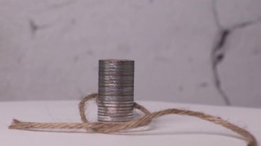 Madeni para ve ip yığınlarıyla örülmüş minyatür bir adam. Ekonomik kıtlık kavramı.