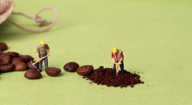 Kahve çekirdekleri ve iki minyatür işçi. İş konsepti olan minyatür insanlar.