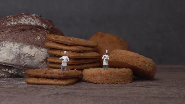 Два Мініатюрних Кухаря Стоять Хрустким Печивом Мініатюрні Люди Бізнес Концепція — стокове відео