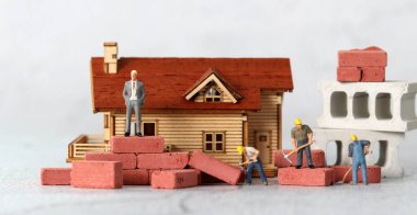 Minyatür ev ve minyatür insanlarla ilgili bir iş konsepti. Gelir eşitsizliği kavramı.