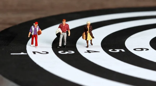Miniature people walking on the target. A business concept for a competitive society.