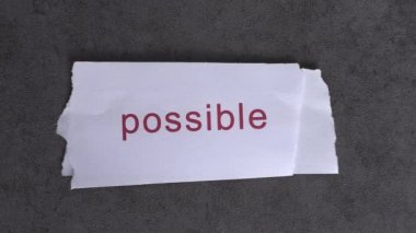 Replace the word impossible with the word possible. Business concept with letters and wobbly paper.