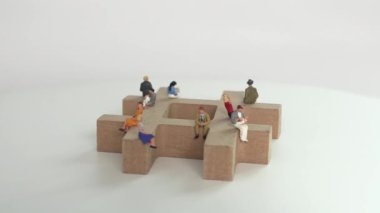 A variety of miniature people sitting on hash tags. Business concept with miniature people.