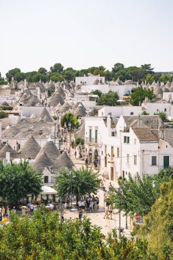 Alberobello, İtalya - 23 Ağustos 2021: Güzel Trulli 'nin panoramik manzarası, Alberobello, Puglia, İtalya' da konik çatısı olan geleneksel Apulian kuru taş barakası,