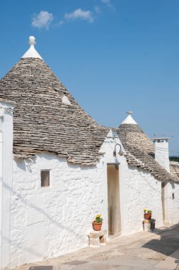 Alberobello, İtalya - 23 Ağustos 2021: Geleneksel Apulian kuru taş duvar kulübesi güzel Trulli grubu Alberobello, Puglia, İtalya 'da konik çatısı olan eski evler
