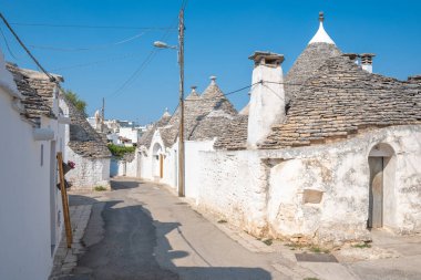 Alberobello, İtalya - 23 Ağustos 2021: Geleneksel Apulian kuru taş duvar kulübesi güzel Trulli grubu Alberobello, Puglia, İtalya 'da konik çatısı olan eski evler