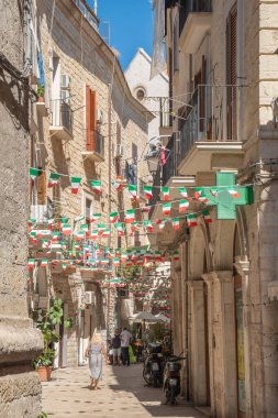 Bari, Puglia, İtalya - 27 Ağustos 2021: İtalyan bayraklarıyla dolu bir yaz gününde, Bari 'nin eski kenti Puglia' da Narrow Caddesi