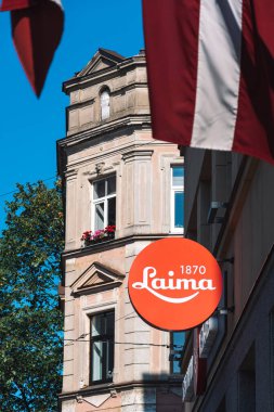 Riga, Letonya - 19 Eylül 2021: Riga, Letonya 'da Laima Çikolata Müzesi Klasik logo ve Letonya bayrakları, dikey