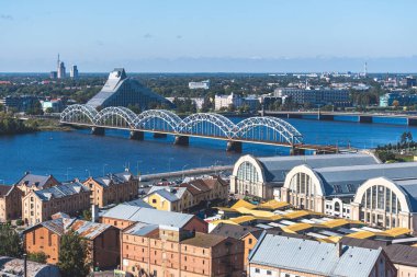 Riga, Letonya - 19 Eylül 2021: Daugava nehri, köprü, Merkez Pazar ve Letonya Ulusal Kütüphanesi ile Riga panoraması