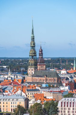 Riga, Letonya - 19 Eylül 2021: St. Peter Kilisesi ve diğer kilise ve binalarla Riga panoraması, Daugava nehri, köprü, finans bölgesi ve Merkez Pazarı, dikey