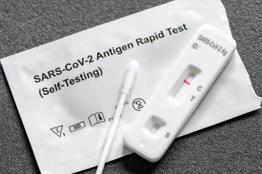 Negatif Covid-19 antijen test kiti, bir basamak koronavirüs antijen hızlı testi, tükürük örneği, akciğerli bir test kutusu, yakın çekim.