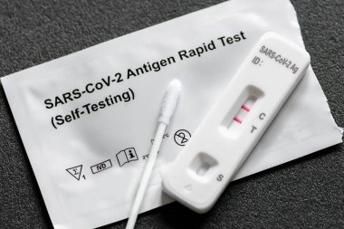 Kendini test etmek için pozitif Covid-19 antijen test kiti, bir basamak koronavirüs antijen hızlı test, tükürük örneği, bir test kutusu, kapatın.