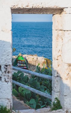 Akdeniz manzarası kayalık kayalık kayalıklar, güzel mavi deniz, bitki örtüsü, taş duvarlar, duvarlar ve eski ahşap botlarla yapılmış raflar, dikey