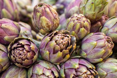 Sokak gıda pazarında yeşil yapraklı taze yeşil enginarlar. Yaklaş.