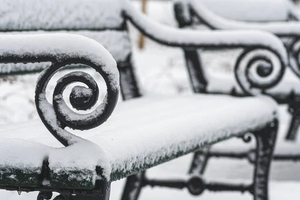 冬の雪に覆われた公園の古いヴィンテージベンチ クローズアップビュー — ストック写真