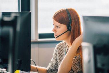 Ofiste çalışan beyaz saçlı güzel bir kız ya da iki monitörün önündeki masada çalışan bir kız. İşine, konsantrasyonuna ve konseptine odaklan.