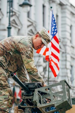 Vilnius, Litvanya - 16 Şubat 2022: Amerikan bayrağı taşıyan bir makineli tüfeğin tepesinde ABD Deniz Piyade Birliği askeri, eğitime ya da savaşa hazırdır.