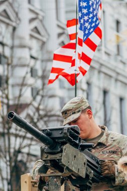 Vilnius, Litvanya - 16 Şubat 2022: Amerikan bayrağı taşıyan bir makineli tüfeğin tepesinde ABD Deniz Piyade Birliği askeri, eğitime ya da savaşa hazırdır.