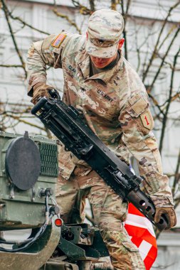Vilnius, Litvanya - 16 Şubat 2022: Amerikan bayrağı taşıyan bir makineli tüfeğin tepesinde ABD Deniz Piyade Birliği askeri, eğitime ya da savaşa hazırdır.