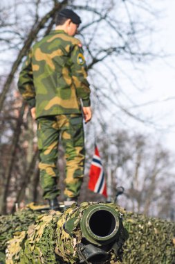 Vilnius, Litvanya - 16 Şubat 2022: Norveç Ordusu zırhlı tankı üzerinde asker ve Norveç bayrağı bulunan top ve kamuflaj zırhı