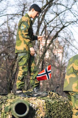 Vilnius, Litvanya - 16 Şubat 2022: Norveç Ordusu zırhlı tankı üzerinde asker ve Norveç bayrağı bulunan top ve kamuflaj zırhı
